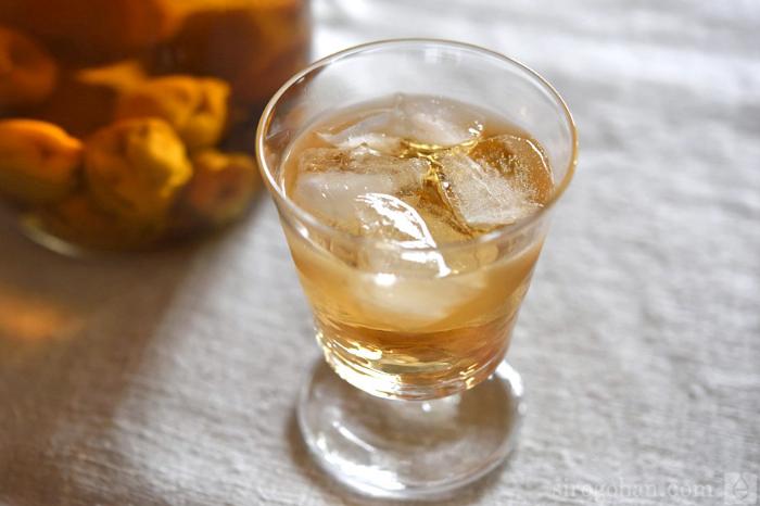 ジン梅酒作りの工程で青梅と氷砂糖を交互に瓶に詰めている様子