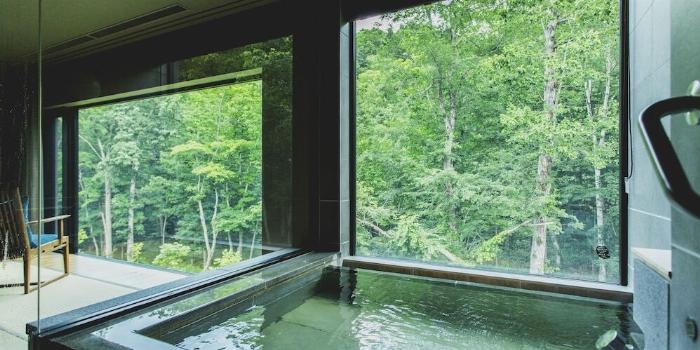 和室の窓辺で美しいグラスに入った日田梅酒をゆっくりと楽しむ様子