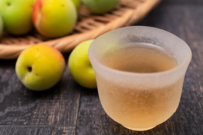 ボトルとグラスに注がれた百年梅酒の高級感あふれるイメージ