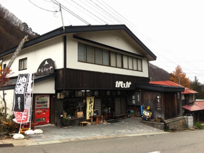 様々な種類のとろとろ梅酒のボトルが並ぶ、おしゃれな酒屋の棚