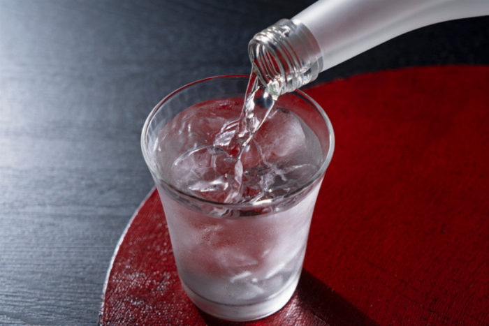 セブンプレミアムの本格梅酒のボトルが木製のテーブルの上に置かれている様子