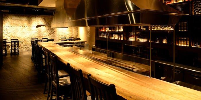 鶯梅酒を注いだロックグラスと氷、背景には和モダンなバーカウンター