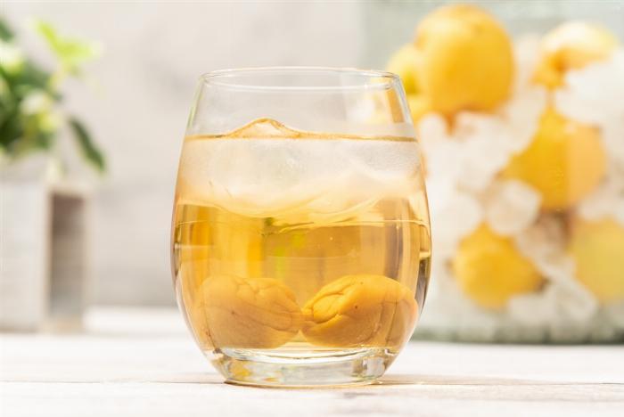 自家製梅酒の瓶から熟成した梅の実を箸で丁寧に取り出している様子