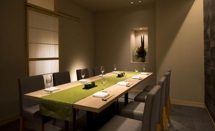 京都のバーカウンターに並べられた梅酒のテイスティングフライト、色合いの異なる梅酒が入った小さなグラスが美しい