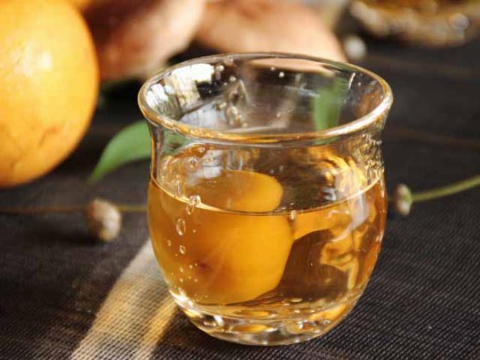 おしゃれなグラスに注がれた琥珀色の梅酒と梅の実